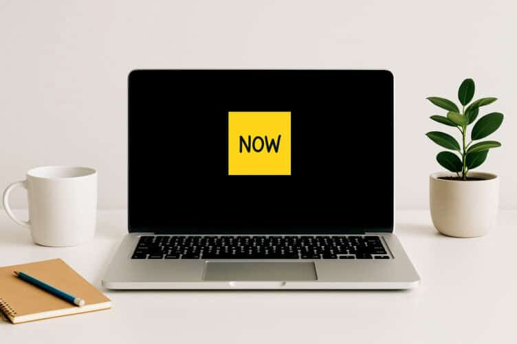 Minimalist desk with laptop and bright sticky note.